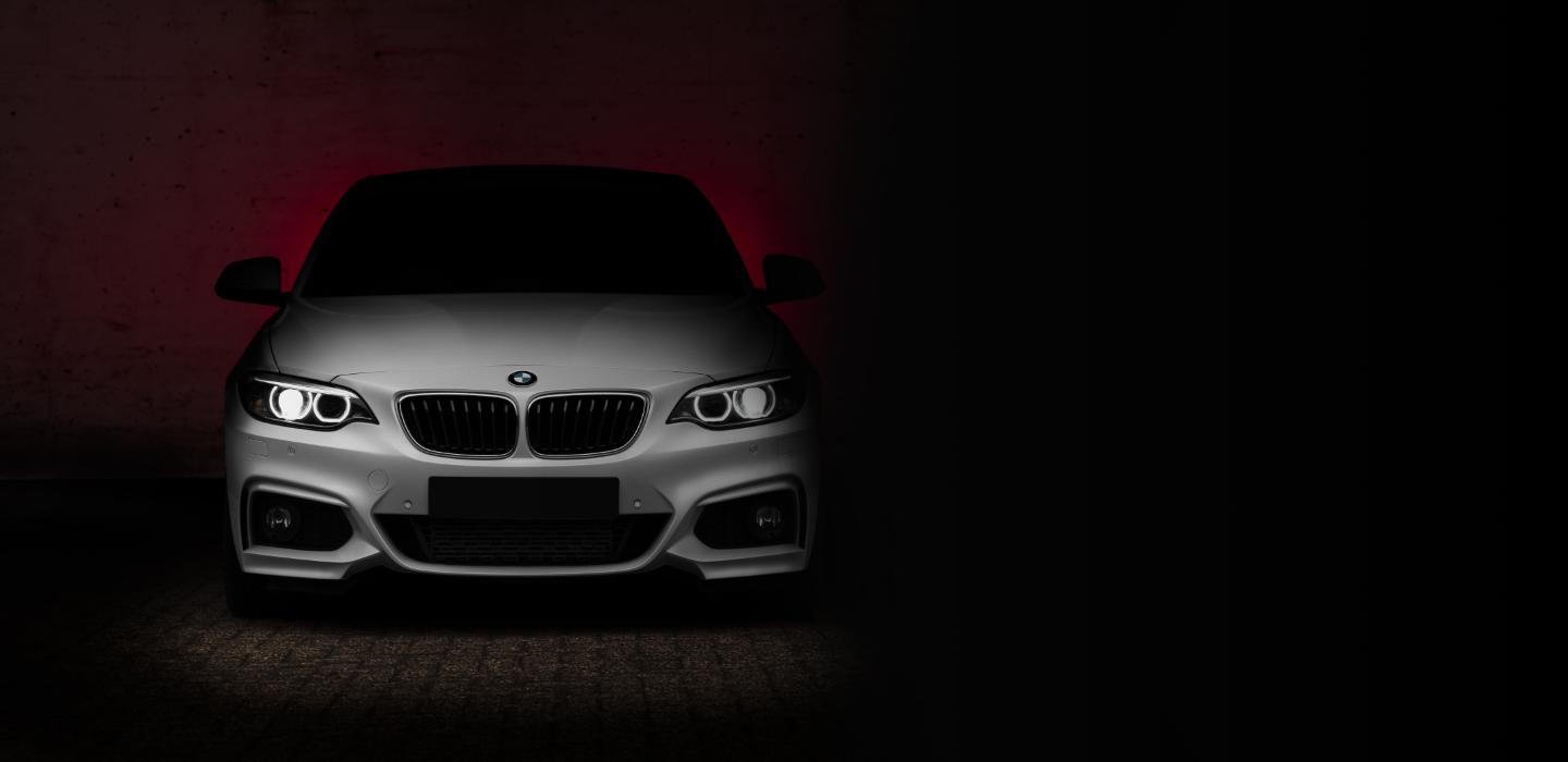 white bmw against a red and black backdrop